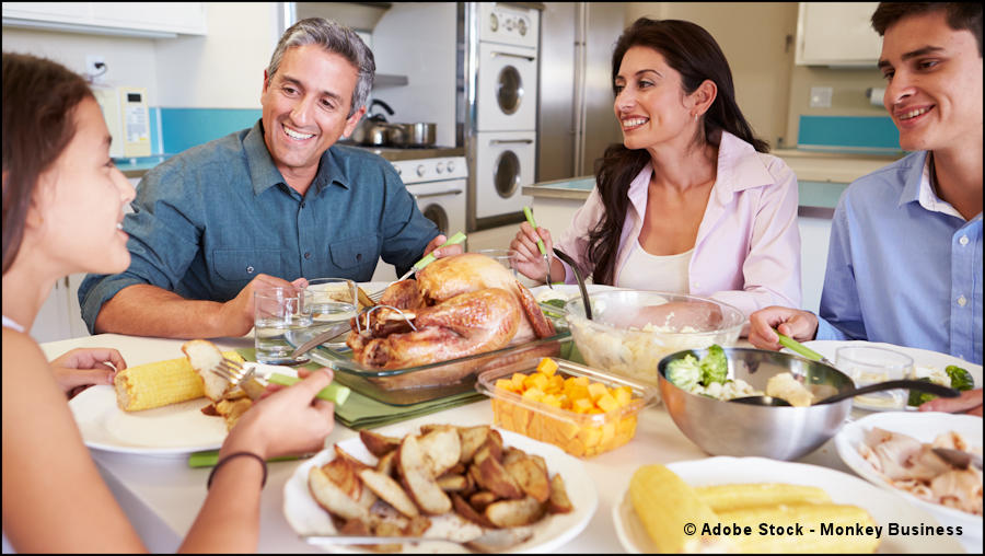 Family of four gathered around dinner table